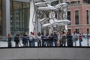 Group of people gathered on an office building plaza looking down to a lower level